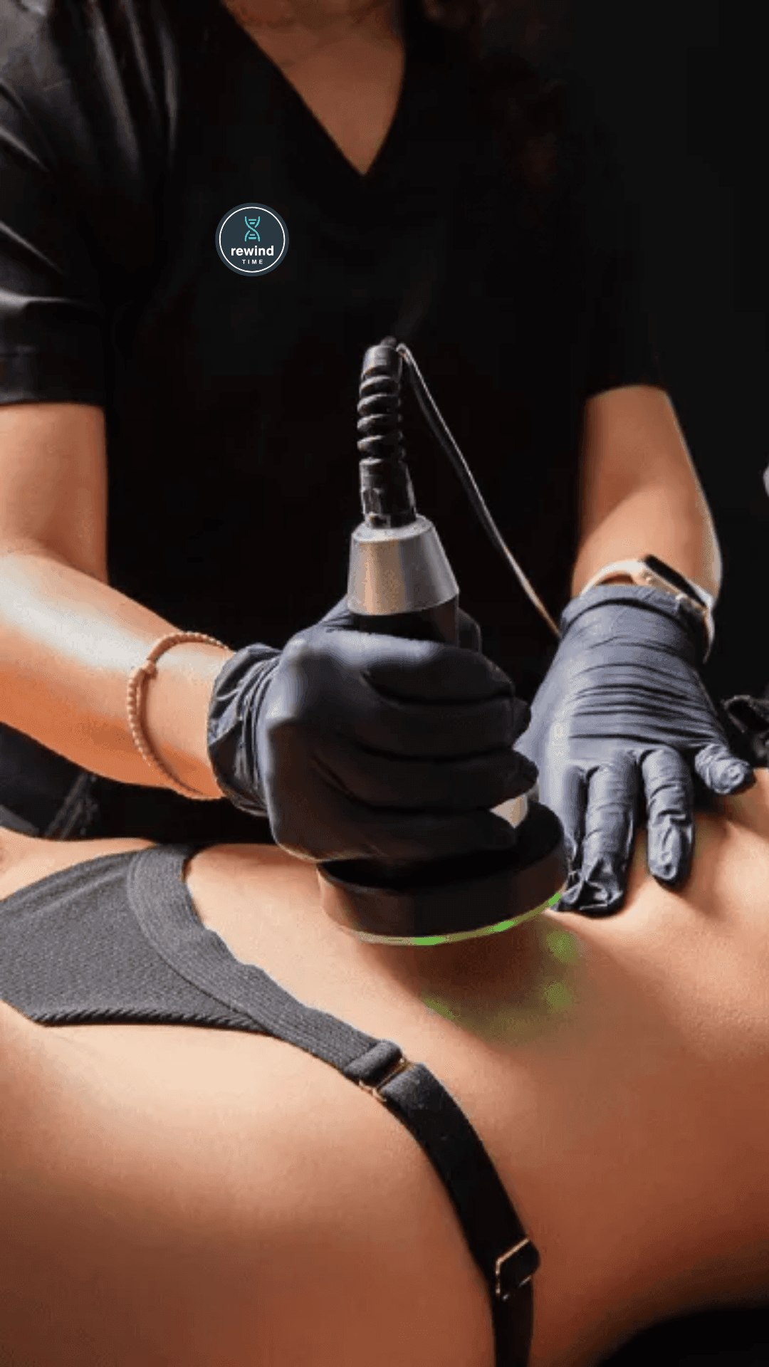A professional performing a non-invasive body contouring treatment on the lower back with a handheld device A professional performing a non-invasive body contouring treatment on the lower back with a handheld device