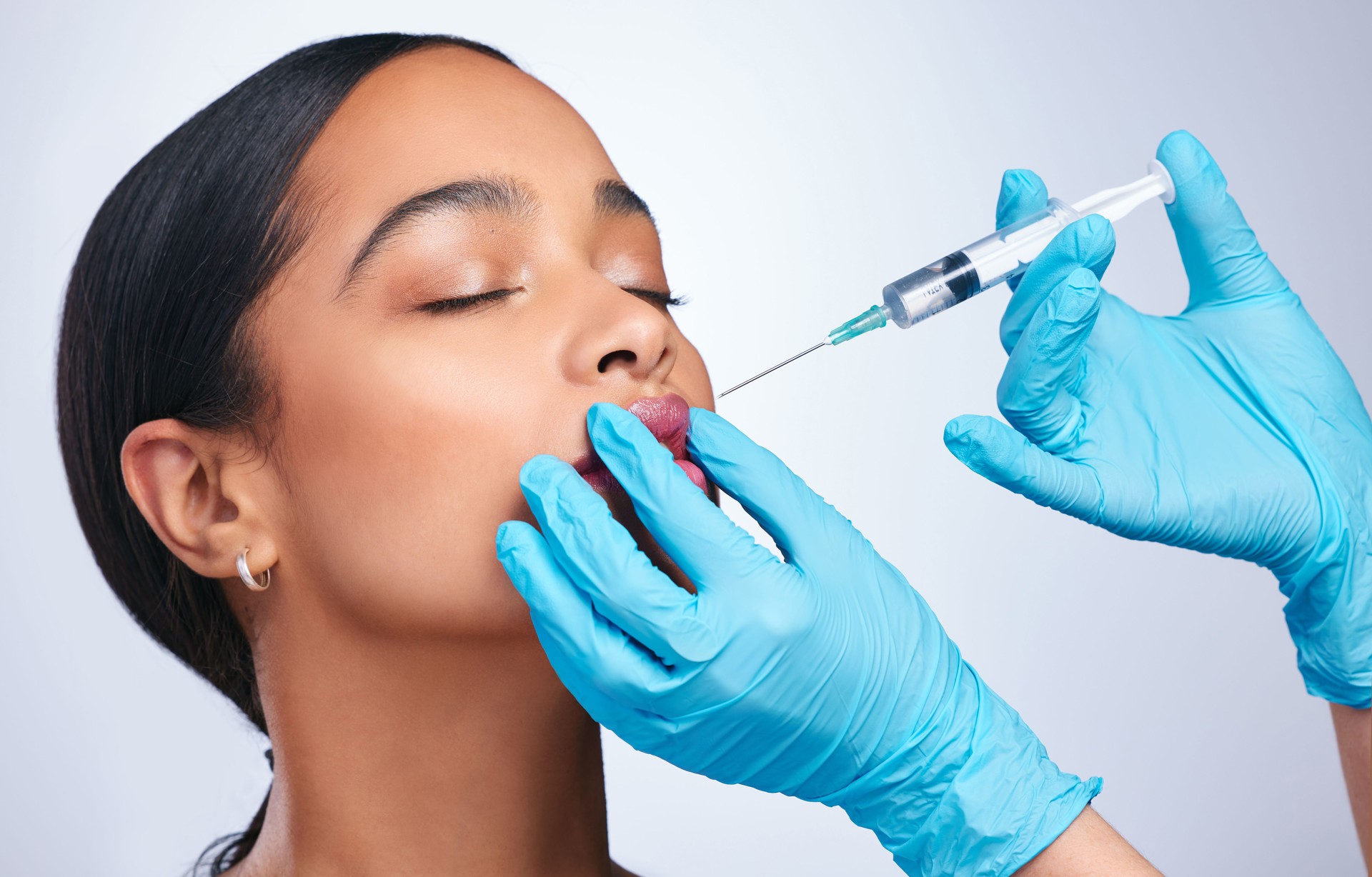 Shot of a beautiful young woman having a botox session against a grey background Shot of a beautiful young woman having a botox session against a grey background